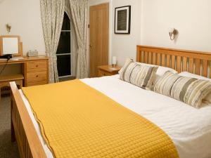 a bedroom with a large bed with a yellow blanket at The Chapel in Staveley +8 photos