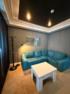 a living room with a blue couch and a table at New Gudauri Atrium in Gudauri