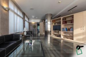a living room with a black couch and a glass table at Hotiday Milano Navigli in Milan