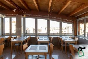 a restaurant with tables and chairs and windows at Hotiday Milano Navigli in Milan