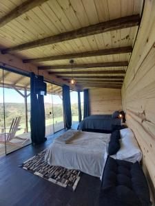 a bedroom with a bed and a couch in a room at Cabanas do Arvoredo in São José do Cerrito