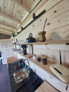 a kitchen in a tiny house with a sink at Cabanas do Arvoredo in São José do Cerrito