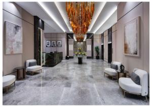 a lobby with chairs and a large chandelier at Vittori Garden in Riyadh