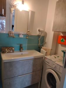 a bathroom with a sink and a washing machine at Appartamento Giuse Mari in Suvereto