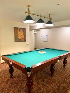 a pool table in a living room with two lights at Hotel-Restaurant Smilga in Kėdainiai