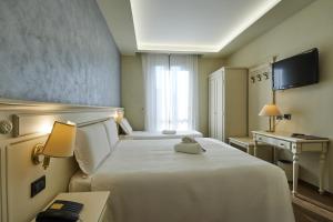 a hotel room with two beds and a desk at Hotel Galimberti in Turin