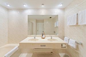 ein Badezimmer mit Waschbecken und großem Spiegel in der Unterkunft Hotel Mozart in Rorschach