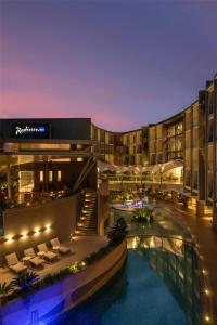 an image of a hotel with a pool at night at Radisson Blu Hotel & Residence Nairobi Arboretum in Nairobi