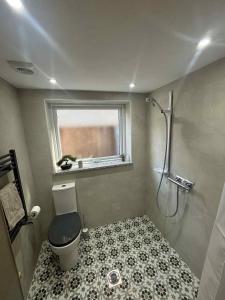 a bathroom with a shower and a toilet and a window at Apartment No 4 in Bridlington +18 photos