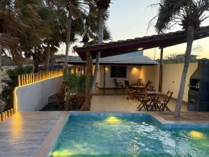 a backyard with a swimming pool and a house at Chalé Anjos Mar in Barrinha