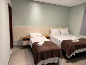 a hotel room with two beds with towels on them at Chalé Anjos Mar in Barrinha