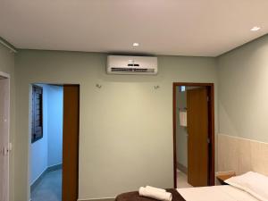 a bedroom with a bed and a air conditioner on the ceiling at Chalé Anjos Mar in Barrinha