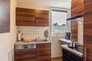 a kitchen with wooden cabinets and a sink at Ferienhaus Jupiter im Sternenpark in Lochow +7 photos