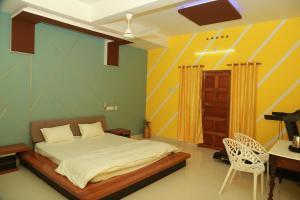 a bedroom with a bed and a desk and a chair at Greeny Homestay in Cochin +22 photos