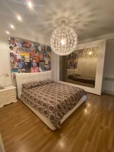 a bedroom with a bed and a chandelier at Blue Zen beachfront apartment in Civitanova Marche