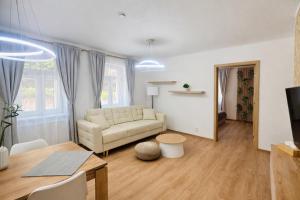 a living room with a couch and a table at Apartmány Ella in Hřensko