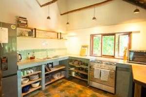 a large kitchen with a sink and a counter at Kitesurf Tofo House - 1 minute walk from beach and center in Praia do Tofo