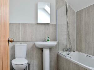 a bathroom with a toilet and a sink and a tub at The Coolins cottage with wood burner in Strathcarron +19 photos