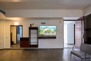 a living room with a flat screen tv on a wall at Urban Opulence in Bangalore