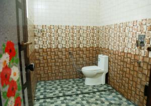 a bathroom with a toilet in a tiled wall at Greeny Homestay in Cochin