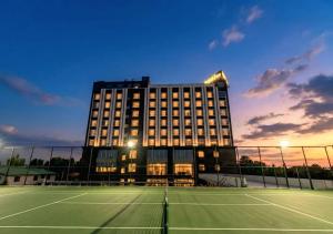 a building with a tennis court in front of it at Kinno International Hotel in Tema
