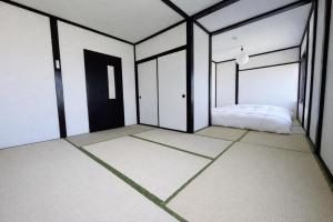 an empty room with a bed in the middle at 椴松 l フルリフォーム l 貸切の一軒家 l 千歳空港まで30分 l Todomatsu in Yuni