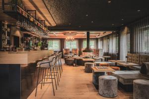 un ristorante con un bar con sgabelli e tavoli di Hotel Christof a Monguelfo