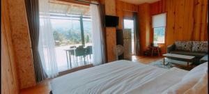 a bedroom with a bed and a large window at บ้านพัก กามู Gamoo homestay in Chom Thong