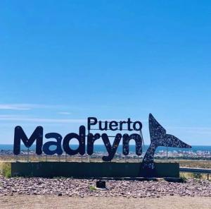 a sign for puerto madryn on the beach at Casa de campo in Puerto Madryn +4 photos