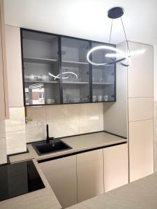 a kitchen with white cabinets and a sink at Apartman 307 in Lukavica
