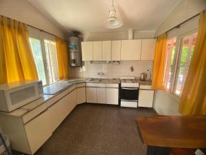 a kitchen with yellow curtains and a stove top oven at Casa los Churumbeles in Potrerillos +9 photos