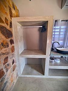 ein Schrank in einer Küche mit einer Ziegelwand in der Unterkunft Blomberg in Clanwilliam