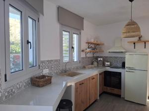 a kitchen with a sink and a white refrigerator at Rhodes Soul Luxury Suites in Afantou +108 photos
