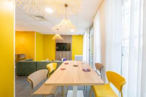 a conference room with a wooden table and yellow chairs at Résidence Nemea Clermont Centre in Clermont-Ferrand +11 photos