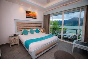 a bedroom with a bed and a large window at Beach Lodge in Pokhara +8 photos