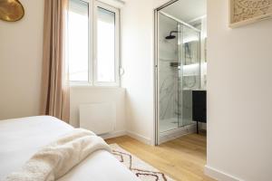 a bedroom with a glass shower and a bed at 304 Chanzy - T1 Spacieux - Gare & Centre - Wifi in Le Mans
