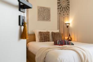 a bedroom with a bed with white sheets and pillows at 304 Chanzy - T1 Spacieux - Gare & Centre - Wifi in Le Mans