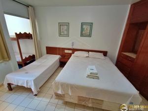 a bedroom with two beds and a window at Flats CTC Araras in Caldas Novas +41 photos