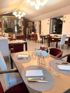 a dining room with tables and chairs in a restaurant at Logis Hôtel de Paris - Restaurant - Pâtisserie in Saint-Avold +16 photos