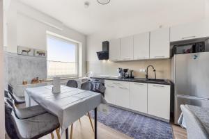 a kitchen with white cabinets and a table and a sink at Heide Ferienwohnung Süd Nr-2 in Schneverdingen