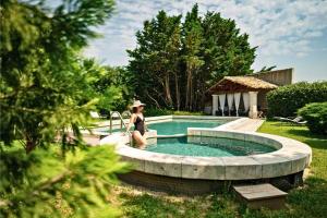 a woman in a hat standing next to a swimming pool at Justin de Provence in Orange
