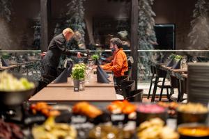 two people sitting at a table in a restaurant at Arctic Panorama Resort in Rovaniemi