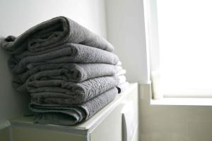 a stack of towels sitting on a shelf in a bathroom at Heide Ferienwohnung Süd Nr-2 in Schneverdingen +16 photos