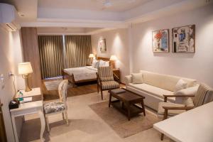 a living room with a couch and a bedroom at Luxury Suites by Eden Wellness and Hospitality in Dehradun