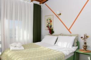 a bedroom with a bed with white sheets and a window at Teras Motel 12 Adults Only in Foça