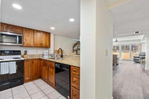 a kitchen with wooden cabinets and a stove top oven at Pier Point South Ocean View Condo B-22 in St. Augustine