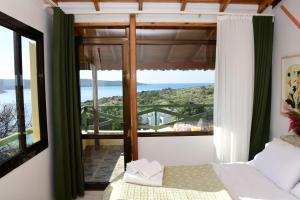 a bedroom with a window with a view of the ocean at Teras Motel 12 Adults Only in Foça