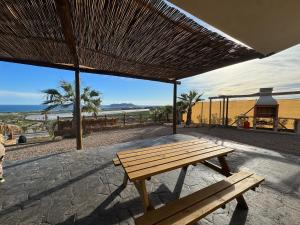 a wooden bench sitting on a patio with a view of the ocean at Villa Loma de Bas 1 y 2 in Águilas