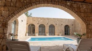 an archway over a swimming pool in a stone building at Golden Heights Resort in Al Ḩanī