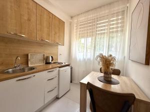 a kitchen with a table and a sink and a counter at Apartments Pribilovic in Budva